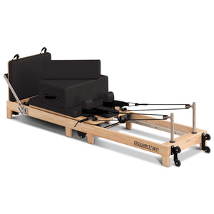 Wooden Selina Pilates Reformer machine with jumpboard and sitting box, black and oak finish, for home gym fitness and Pilates exercises.