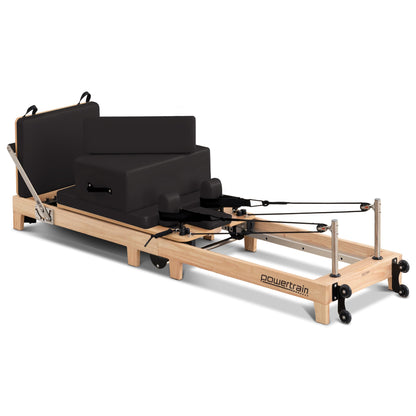 Wooden Selina Pilates Reformer machine with jumpboard and sitting box, black and oak finish, for home gym fitness and Pilates exercises.