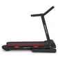 Powertrain K200 electric folding treadmill for home gym, showing the running belt and control panel in a fitness setting.