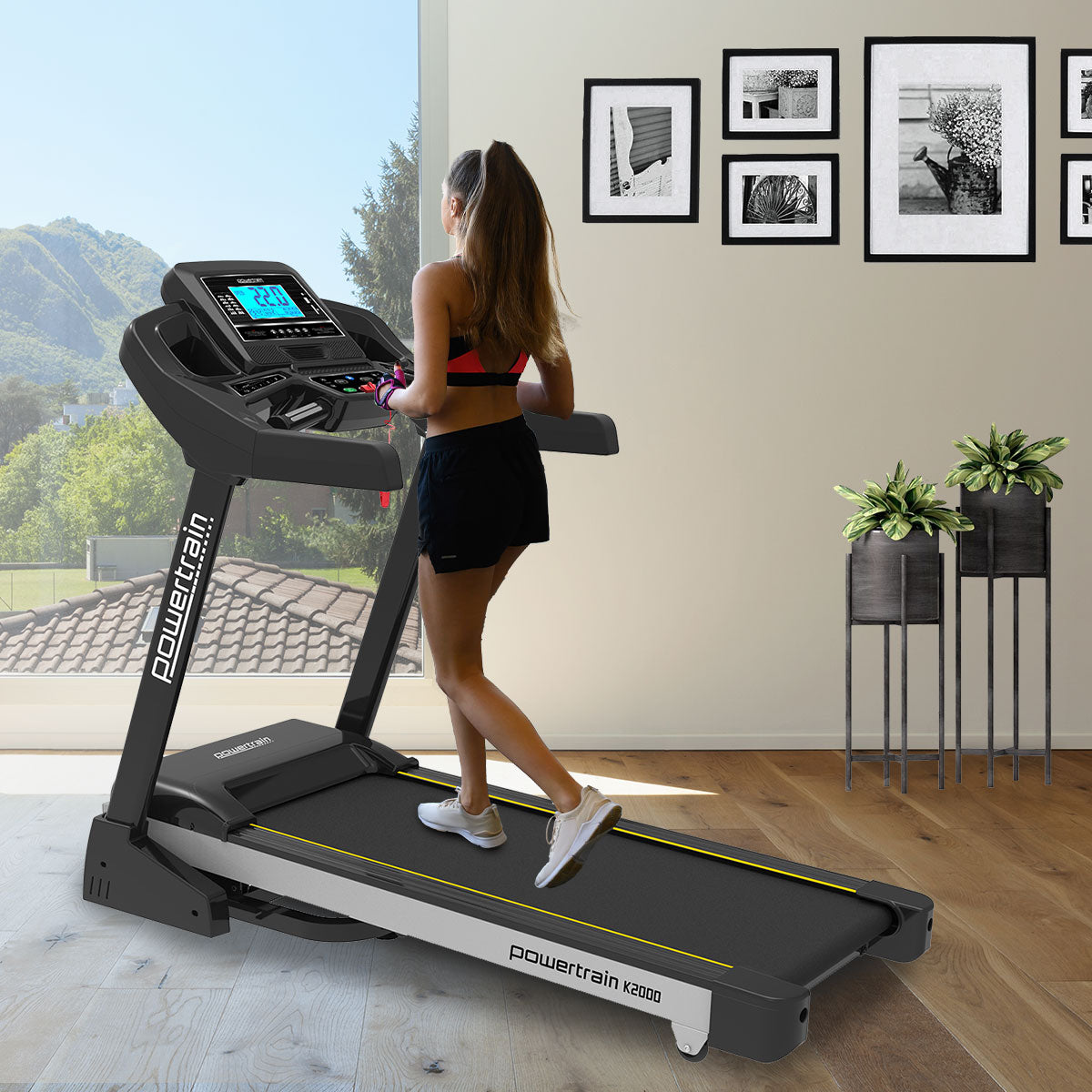Powertrain K2000 treadmill with fan and auto incline, showing a running belt, digital display, and control panel for fitness training.
