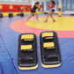 Black Thai pads kickboxing punching shield with adjustable straps for boxing and martial arts training.
