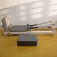 Folding Pilates reformer machine for full-body fitness, featuring adjustable straps and padded carriage for home workouts.