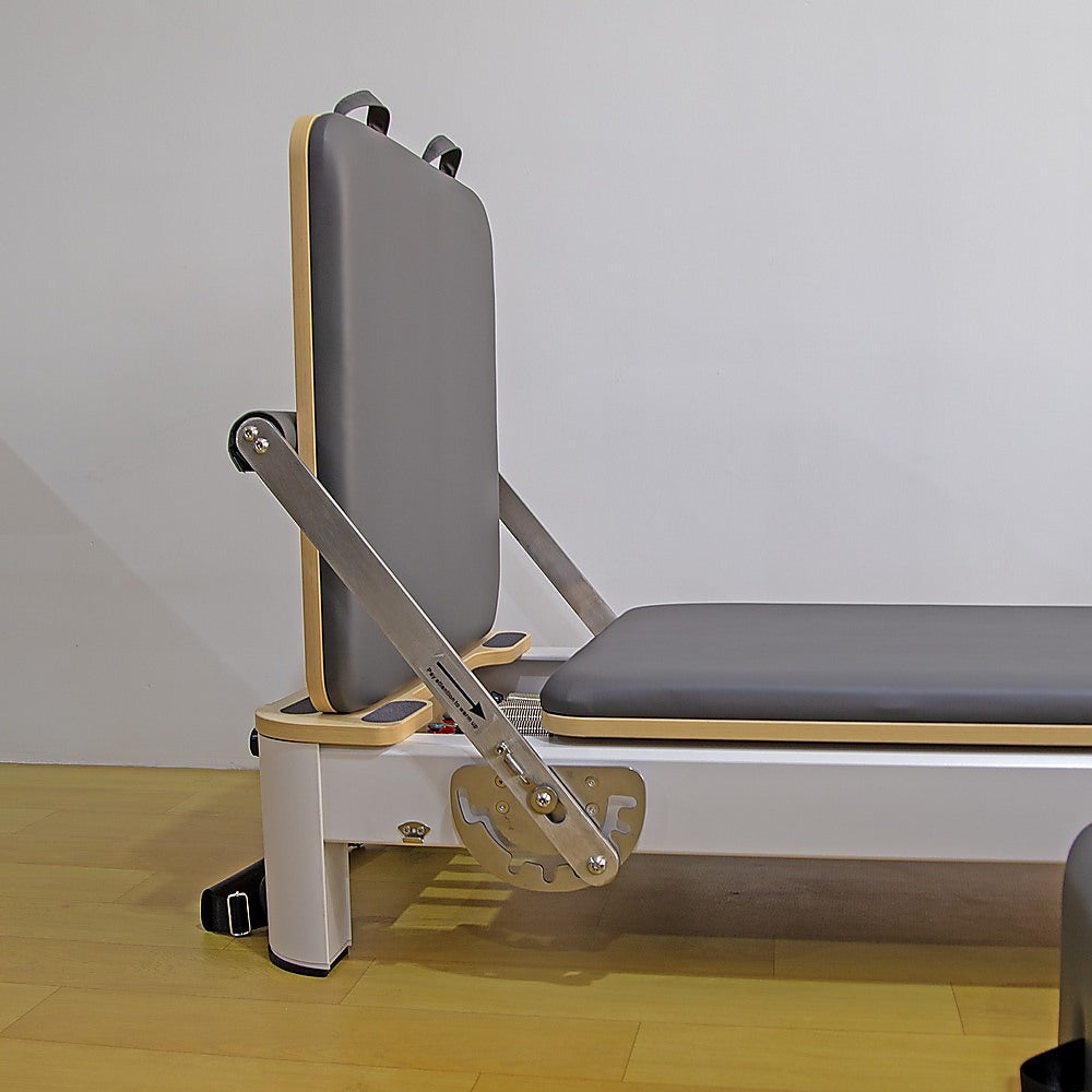 Folding Pilates reformer machine for full-body fitness training, with padded carriage and adjustable resistance for home workouts.
