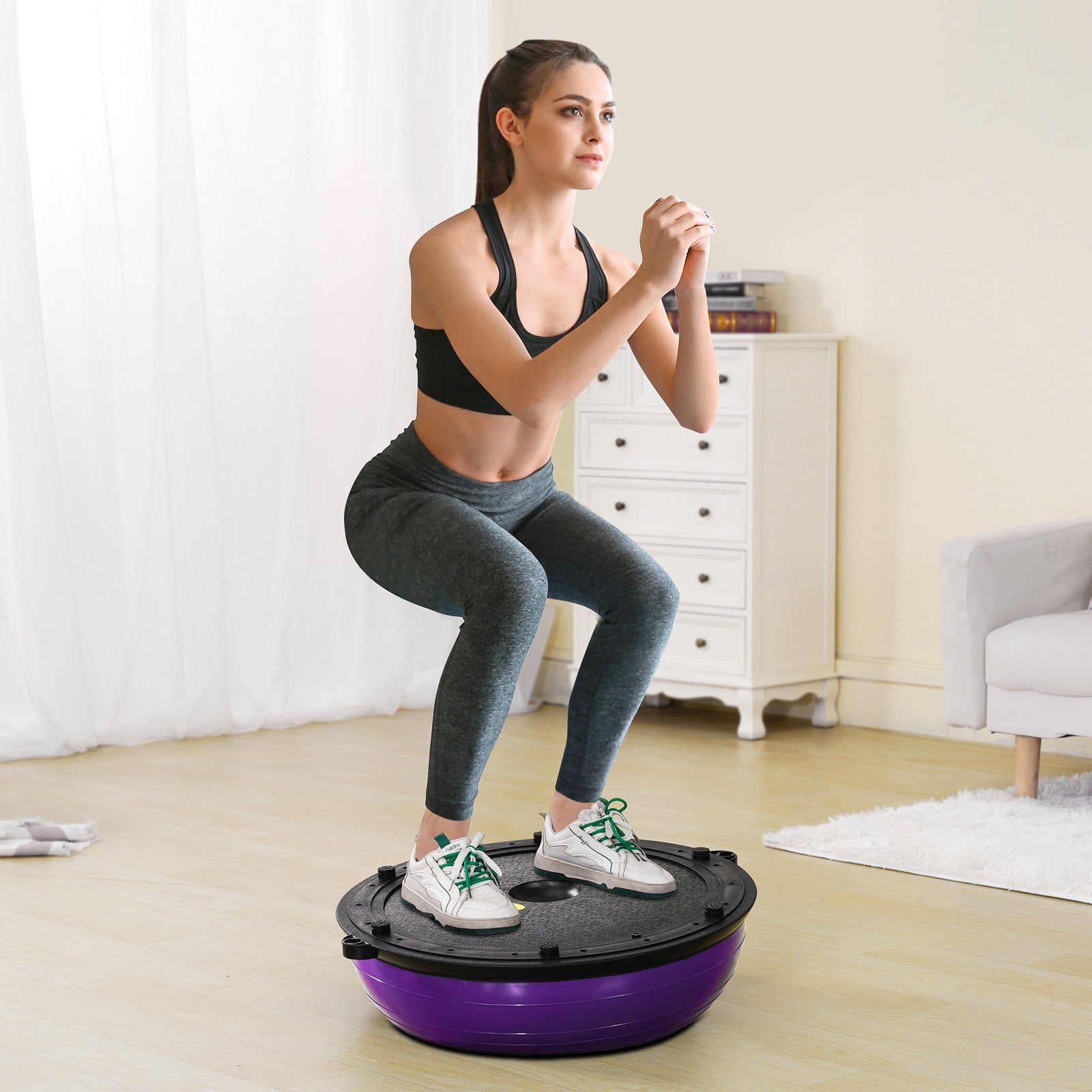 Purple 23-inch stability ball with resistance bands and foot pump, used for full-body workouts and balance training at home.